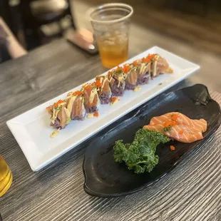 two plates of sushi and a glass of beer