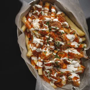 a tray of french fries covered in sauce