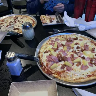 Hawaiian specialty pizza and a pepperoni pizza.