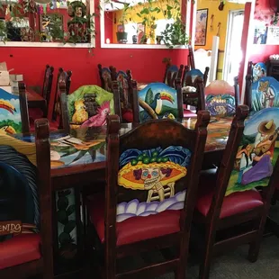 a dining room with painted chairs