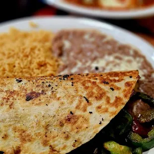 Dinner Quesadilla (chicken, steak, shrimp) cooked with onions, peppers, tomatoes and Chipotle sauce. Served with rice and beans