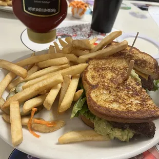 Avocado cheeseburger with sourdough bread and ranch dressing for French fries.