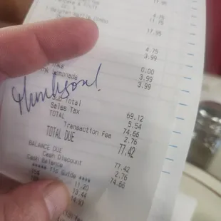 a hand holding a receipt