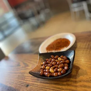 a plate of nuts and a bowl of groundnuts