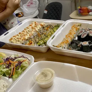 two containers of different types of sushi
