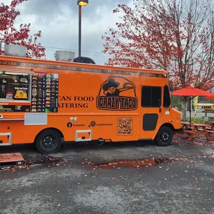 an orange food truck parked in a parking lot