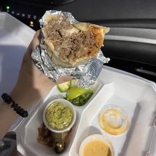 a person holding a tray of tacos