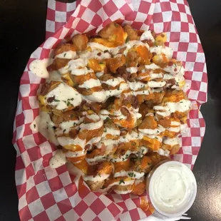 a plate of fries with a side of ranch dressing