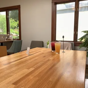 One angle of side seating room. Large table. Two tables for two. Small wall-facing table with two chairs.