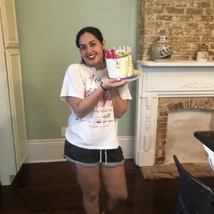 a woman holding a birthday cake