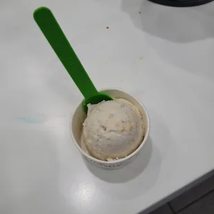 a cup of ice cream with a green spoon