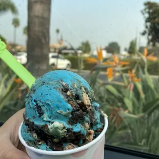 a hand holding a cup of ice cream