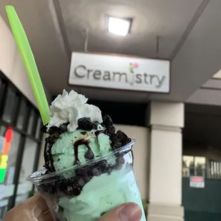 a hand holding a cup of ice cream