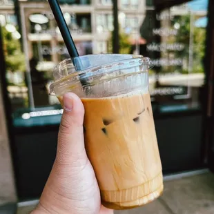 a hand holding a cup of iced coffee