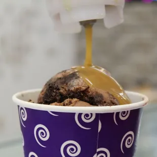 ice cream being poured into a cup