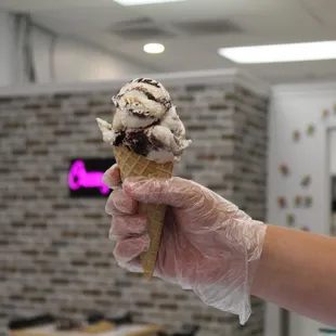 a hand holding an ice cream cone
