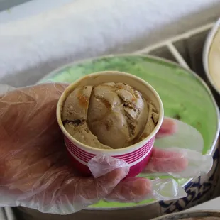 a hand holding a cup of ice cream