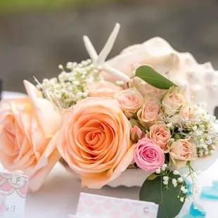 Seashell filled with roses and starfish perfect for beach themed wedding