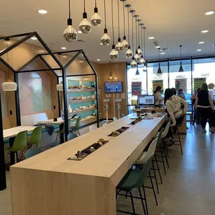 Lobby area with check-in kiosks and tables for individuals or small groups.