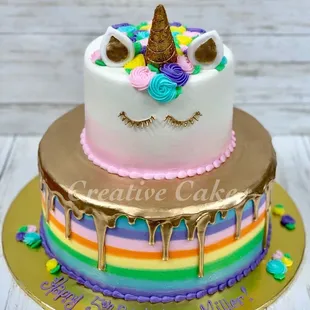 a rainbow cake with a unicorn on top
