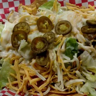 a plate of nachos with cheese and jalapenos