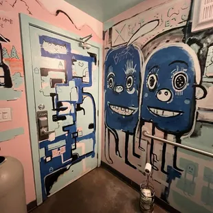a bathroom with graffiti on the walls