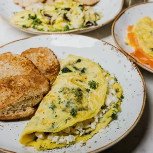 a plate of eggs, toast, and bread