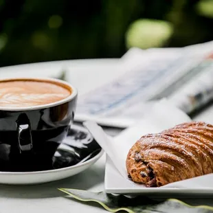 a cup of coffee and a croissant