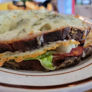 Croque monsieur,  a slice of ham a slice of romaine and some sauce rubbed on the inside bread topped with melted cheese