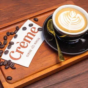 a cup of coffee on a wooden tray