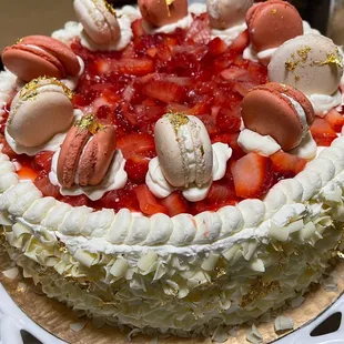 a cake with strawberries and macarons