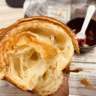 a hand holding a croissant