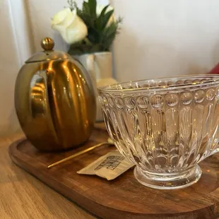 a glass cup on a wooden tray