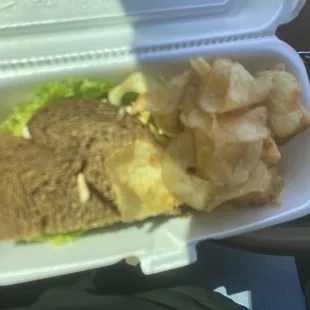 chicken salad sandwich on square bread and house chips