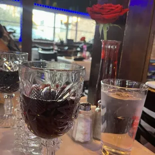 a glass of wine with a rose in it