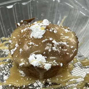 Made-from-scratch Praline Cornbread drizzled in praline sauce topped woth powdered sugar.