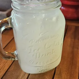 a mason jar of lemonade with a straw in it