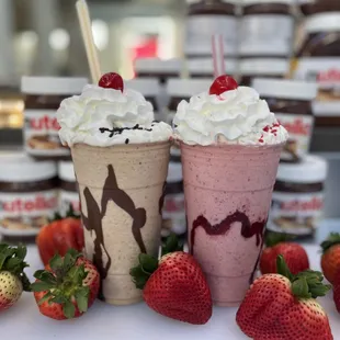 two milkshakes with whipped cream and strawberries