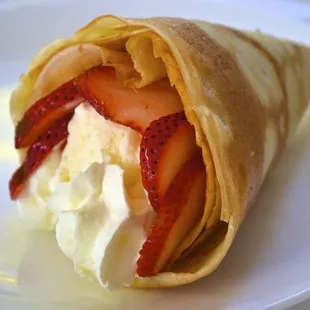 a crepe with whipped cream and strawberries