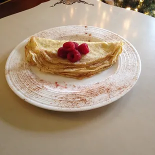a crepe with raspberries on it