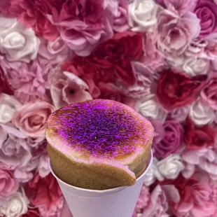 Signature creme brulee style. Lighting made it look pink. Crepe cone, sweet cream and strawberries inside, crunchy sugar top.