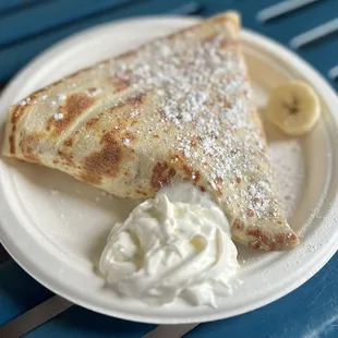 a plate of crepes and whipped cream