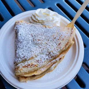 a plate of crepes with whipped cream