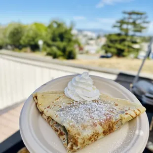 a person holding a plate of crepes