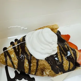Strawberry crepe with dark chocolate drizzle and whipped cream