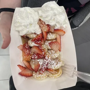 Mini pancakes, maple syrup, strawberries, powder sugar and whipped cream