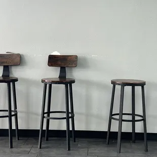 three stools against a wall