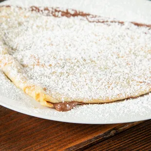 a plate of crepes with powdered sugar on top