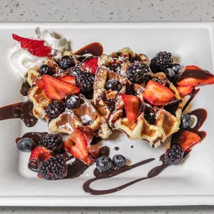 trawberries, blueberries, and chocolate syrup