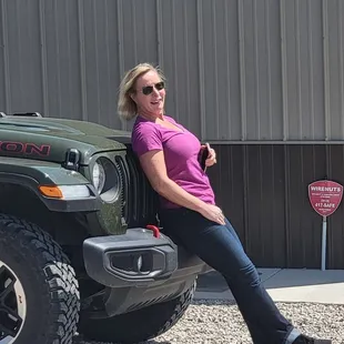 a woman leaning against a jeep